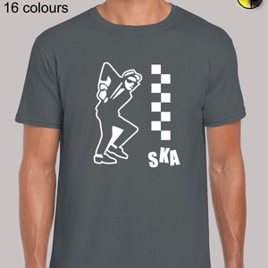 May include: A dark grey t-shirt featuring a white graphic of a person dancing with the word "SKA" and a chequered pattern.
