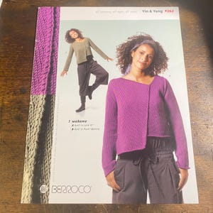 May include: A magazine cover featuring a woman wearing a purple knit sweater. The text reads "Yin & Yang #262" and "1 wakame". The cover also shows a woman wearing a green sweater and dark pants. The Berroco logo is at the bottom.