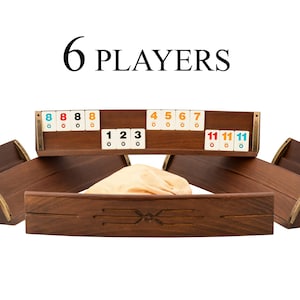 May include: A wooden board game set for six players. The set includes six wooden tile holders, a central wooden tray, and tiles with numbers and colors. The text "6 PLAYERS" is displayed above the game.