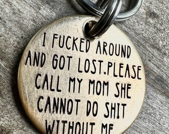 May include: A silver-toned metal keychain with a round tag that reads "I fucked around and got lost. Please call my mom she cannot do shit without me."