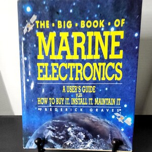 May include: A book titled "THE BIG BOOK OF MARINE ELECTRONICS" with a blue cover featuring yellow text and illustrations of satellites and a planet. The book is a user's guide on buying, installing, and maintaining marine electronics.