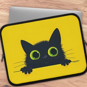 May include: A rectangular laptop sleeve with a bright yellow background featuring a graphic illustration of a black cat with large green eyes peeking over the bottom edge. The cat has visible whiskers and paws resting on the edge. The text Whimsteria is printed in the bottom right corner.