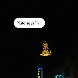 Może przedstawiać: Neonowy znak z Plutem psem, który mówi "hi" nad budynkiem z szyldem "Pluto's" i innym szyldem z napisem "Gifts & Jewelry".