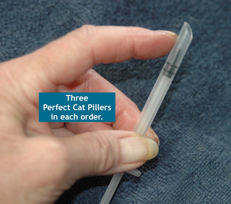 Peut inclure: Une seringue en plastique transparente contenant trois petites pilules. Le texte "Three Perfect Cat Pillers in each order." est visible sur l'image.