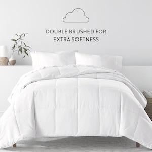 May include: White down comforter with a quilted design. The comforter is on a bed with white pillowcases. The text "DOUBLE BRUSHED FOR EXTRA SOFTNESS" is above the bed.