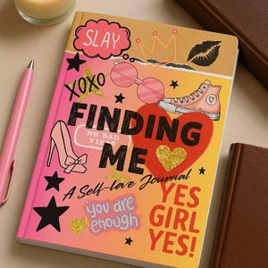 May include: A self-love journal titled "Finding Me" with a pink and yellow cover. The cover features illustrations of sunglasses, a high-heeled shoe, a sneaker, and the words "SLAY", "XOXO", and "YES GIRL YES!". A lit candle and a pen are next to the journal.