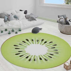 May include: A round green and white rug with a kiwi fruit design. The rug has a light green background with a white center and a dark green kiwi fruit design.