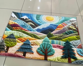 Op de afbeelding: Een kleurrijk tapijt met een patchwork-ontwerp van bergen, bomen en een zon. Het tapijt is gemaakt van een zacht, pluche materiaal en heeft verschillende kleuren, waaronder groen, blauw, geel en bruin.