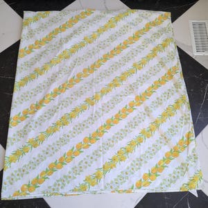 May include: White sheet with diagonal rows of yellow tulips and orange fruit. The sheet also features white daisies and green leaves. The pattern is repeated across the entire sheet.