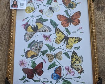 May include: A framed print featuring a collection of various butterflies in shades of yellow, orange, brown, and blue, interspersed with green vines and pink flowers. The artwork is enclosed in a textured gold frame with black corner protectors.