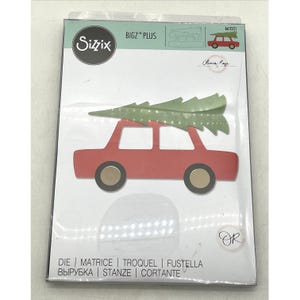 May include: Sizzix Bigz Plus die set featuring a red car carrying a green Christmas tree. The die set includes the text "DIE | MATRICE | TROQUEL | FUSTELLA ВЫРУБКА | STANZE | CORTANTE". The packaging also includes the text "Olivia Rose".