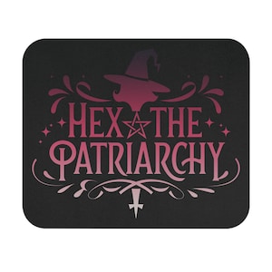 Puede incluir: Alfombrilla de ratón rectangular negra con esquinas redondeadas. El diseño presenta el texto "HEX THE PATRIARCHY" en rosa, con un sombrero de bruja y un gráfico de estrella. El fondo es negro con adornos decorativos rosas.