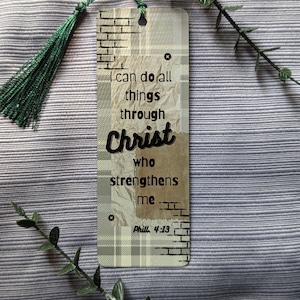 May include: A beige and brown bookmark with a green tassel. The bookmark has a plaid pattern and a brick pattern. The text on the bookmark reads "I can do all things through Christ who strengthens me.  Phil. 4:13"