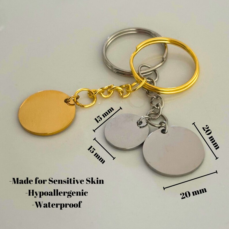 May include: Gold and silver key chain with two round metal tags. The larger tag is 20 mm in diameter and the smaller tag is 15 mm in diameter. The key chain is made for sensitive skin, hypoallergenic, and waterproof.