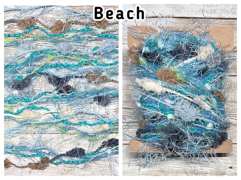 May include: Close-up of two skeins of yarn with a beach theme. The yarn is a mix of blues, greens, and neutral colours, with a textured, fluffy appearance. The word "Beach" is written in black text at the top.