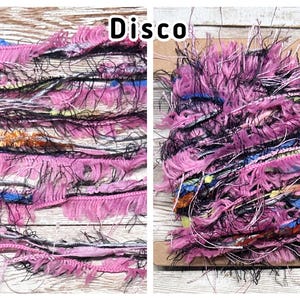 May include: A bundle of multi-textured art yarn labelled Disco, featuring a mix of pink, black, blue, and metallic orange fibres. The yarn includes fringed ribbons, fuzzy strands, and thin metallic threads wound around a flat cardboard spool.