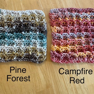 May include: Two crocheted dishcloths, one in a "Pine Forest" colorway with shades of brown, green, and white, and the other in a "Campfire Red" colorway with shades of red, orange, and white.