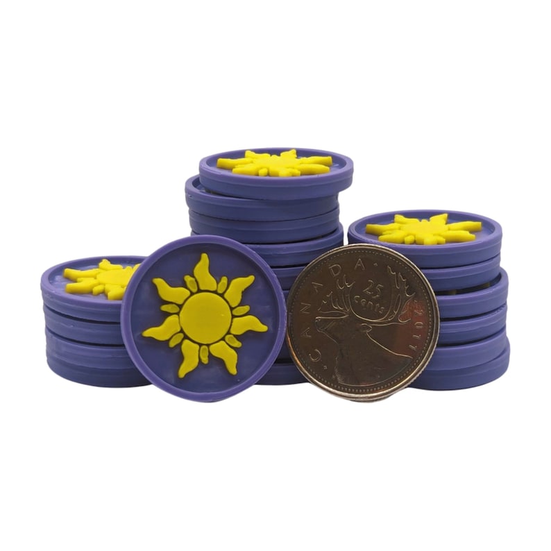 Puede incluir: Montones de fichas circulares moradas y amarillas con un dise&ntilde;o de sol, junto a una moneda canadiense. Las fichas tienen un dise&ntilde;o de sol amarillo sobre un fondo morado.