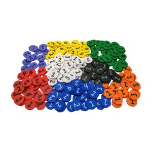 Puede incluir: Una colección de fichas de plástico de colores con los números 1, 2, 3 y 4 impresos en ellas. Las fichas son de color rojo, azul, verde, amarillo, blanco, negro y naranja.