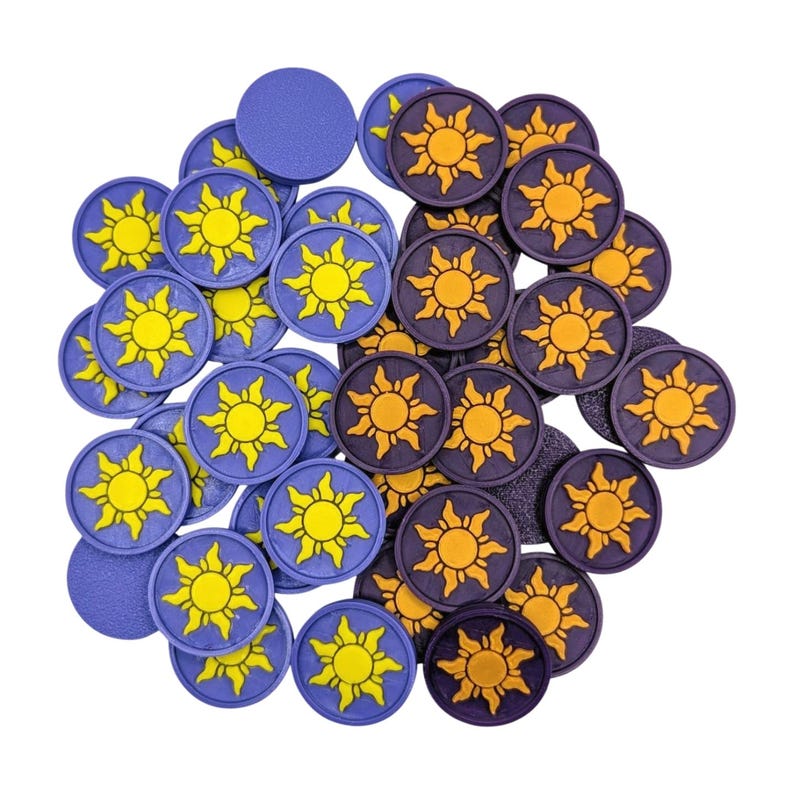 Puede incluir: Una colecci&oacute;n de fichas de juego circulares en tonos morados y negros. Las fichas presentan un dise&ntilde;o de sol amarillo. Algunas fichas son de color morado liso. Las fichas est&aacute;n dispersas sobre un fondo blanco.