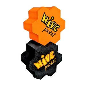 Peut inclure: Deux pièces hexagonales du jeu Hive Pocket. L'une est orange avec du texte noir, l'autre est noire avec du texte jaune. Le texte sur chaque pièce indique "Hive pocket" dans une police stylisée. Les pièces sont empilées l'une sur l'autre.