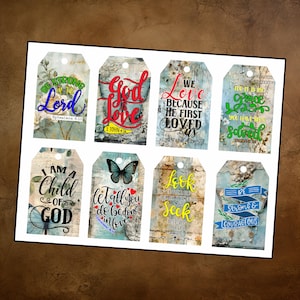 May include: A collection of eight decorative gift tags with inspirational quotes and Bible verses. The tags feature various designs, including floral backgrounds, butterflies, and distressed textures. The color palette includes blues, greens, and yellows.
