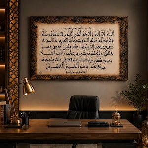 May include: A rectangular wall art piece featuring black Arabic calligraphy on a cream-colored background, enclosed in a dark, textured, distressed frame. The script displays the Ayat al-Kursi verse with intricate, traditional lettering style.