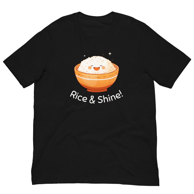 May include: Black t-shirt featuring a cartoon illustration of a bowl of rice with a smiling face. The bowl is orange with a white interior. The text "Rice & Shine!" is printed below the bowl in white.