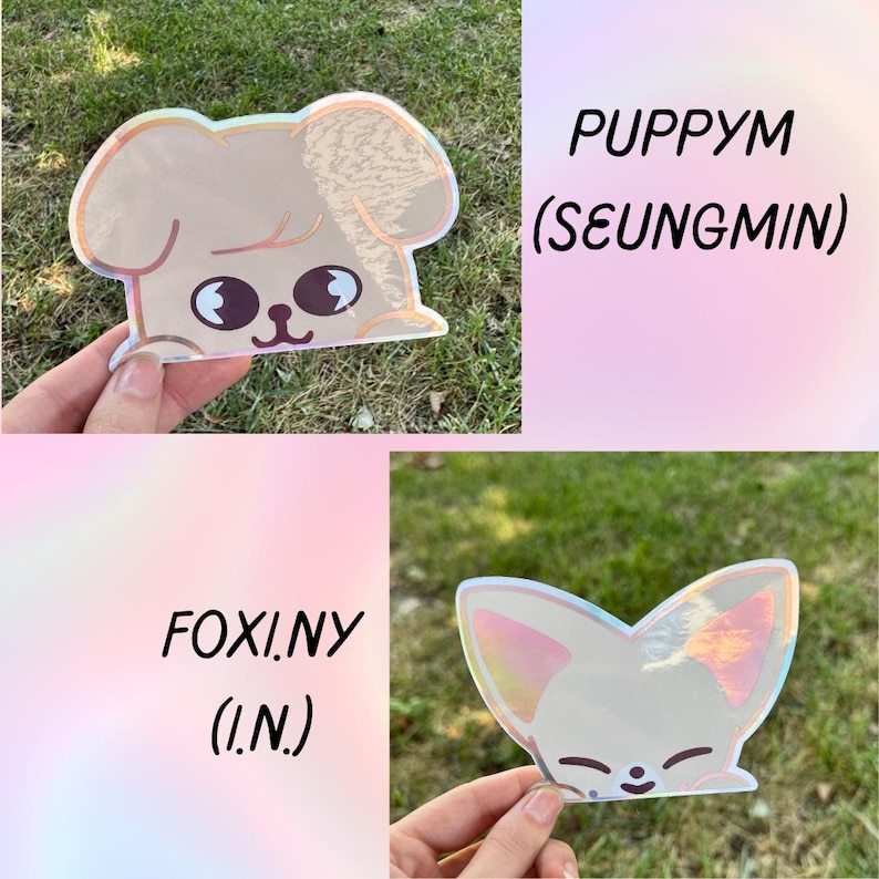 May include: Two holographic stickers featuring cartoon animal designs. One is a puppy with the text "PUPPYM (SEUNGMIN)". The other is a fox with the text "FOXI.NY (I.N.)". Both stickers have a pearlescent finish and are held up by a hand.