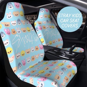 Könnte beinhalten: Hellblaue Autositzbezüge mit einem sich wiederholenden Muster aus Cartoon-Tiergesichtern in verschiedenen Farben. Der Text "Stray Kids" ist in einer stilisierten Schriftart über den Sitzen geschrieben. Eine kreisförmige Grafik lautet "Stray Kids Car Seat Covers."