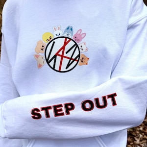 May include: White hoodie featuring a graphic of cartoon animal faces around a black and red design. The sleeve displays the words "STEP OUT" in red letters with a black outline.