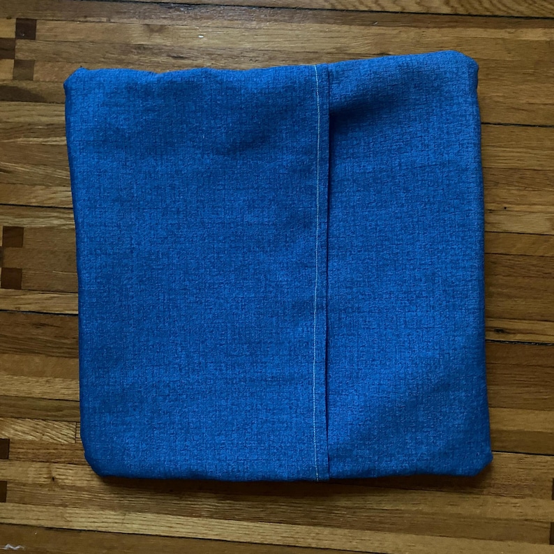 Pode incluir: Uma capa de almofada azul com uma costura branca no centro.