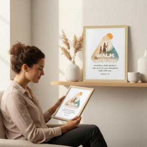 May include: A framed print with the words "WALK with me" and a watercolor illustration of two figures walking. The print is displayed on a shelf with other decorative items. The image also shows a woman holding a similar framed print.