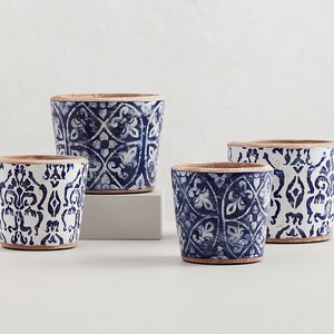 May include: Four ceramic planters with blue and white geometric patterns. The planters are different sizes and have a rustic, hand-painted look.