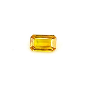 May include: A rectangular-cut, golden-yellow gemstone. The gem is set against a white background, highlighting its clarity and colour. The cut of the stone allows light to reflect, creating a brilliant appearance. This gemstone is suitable for jewellery.