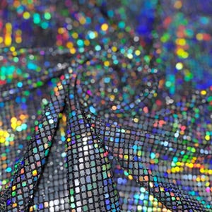May include: Close-up of a black, iridescent fabric with a square grid pattern. The fabric is heavily textured and reflects a multitude of colors, including blue, green, yellow, and red, creating a shimmering effect. The fabric is draped, showing folds and shadows.