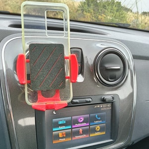 Peut inclure: Un étui de téléphone transparent avec un support de téléphone rouge et noir qui y est attaché. L'étui de téléphone est monté sur le tableau de bord d'une voiture avec un écran affichant un menu avec des options pour la radio, le multimédia, le téléphone, la carte et la navigation.