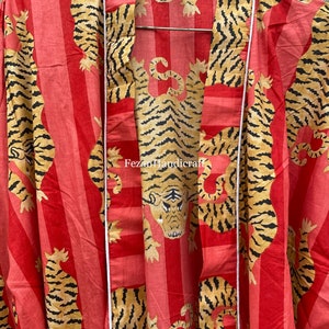 May include: A red and white striped kimono with a tiger print. The kimono has a white sash and the text "Fezan Handicraft" is printed on the front.