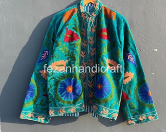 May include: Teal embroidered jacket with floral and leaf patterns in red, orange, and blue. The jacket has a high collar and long sleeves. The text "fezanhandicraft" is visible on the front.