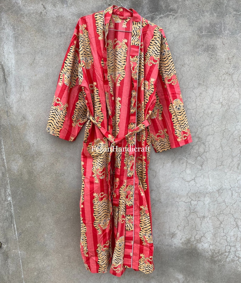 May include: A red and gold striped robe with a tiger print. The robe has a tie belt and long sleeves.