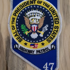 May include: A blue and yellow embroidered patch featuring the Presidential Seal of the United States, the words "SEAL OF THE PRESIDENT OF THE UNITED STATES", "HIGHWAY PATROL", and the number "47".