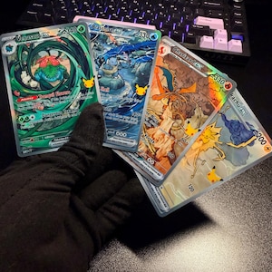 Könnte beinhalten: Eine Sammlung von vier holografischen Sammelkarten mit Venusaur ex, Blastoise ex, Charizard ex und Pikachu ex. Jede Karte zeigt detaillierte Charakterillustrationen, KP-Werte und Fähigkeitstexte sowie ein kleines goldenes Pikachu-Jubiläumslogo.