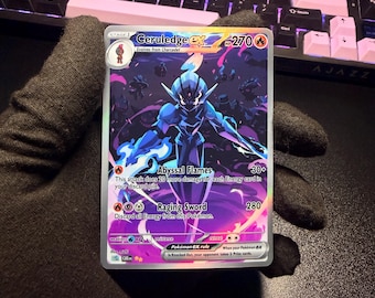 May include: A Ceruledge ex trading card with 270 HP, featuring a dark blue armored character with glowing purple and blue flames. The card displays the attacks Abyssal Flames and Raging Sword, with a holographic finish and a stage 1 evolution icon.