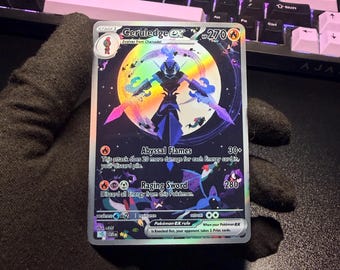 May include: A holographic Ceruledge ex trading card with 270 HP, featuring a dark blue character silhouette against a large yellow moon. The card displays the attacks Abyssal Flames and Raging Sword, along with various small creature illustrations.