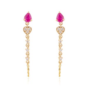 May include: A pair of gold drop earrings featuring a pear-shaped pink gemstone at the top, followed by a heart-shaped setting containing three small clear stones, and a delicate chain dangling downward with three additional small clear stones.
