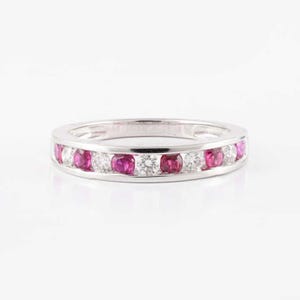 May include: A white gold band ring with alternating pink rubies and diamonds.