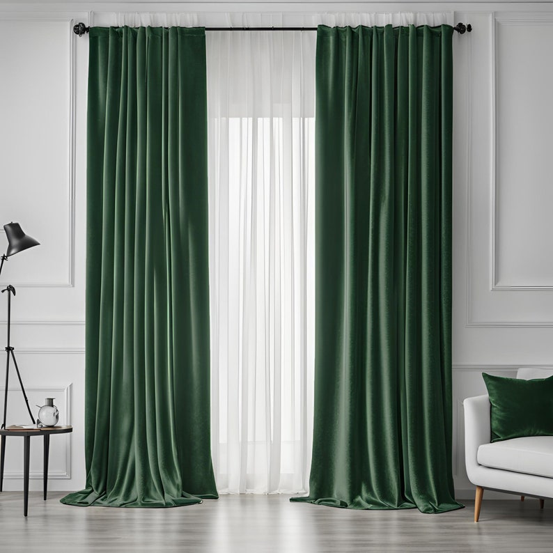 May include: A pair of dark green velvet curtains with a white sheer curtain behind them. The curtains are hung on a black curtain rod.