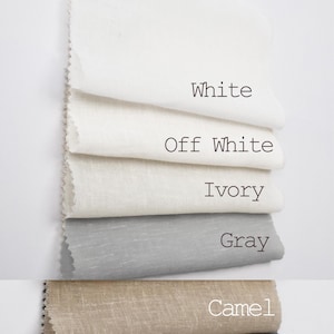 May include: Five fabric swatches in different shades of white, gray, and beige. The swatches are labeled "White", "Off White", "Ivory", "Gray", and "Camel".