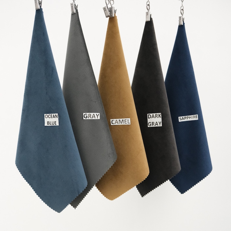 Puede incluir: Cinco muestras de tela colgando de pinzas. Las muestras son de color azul oc&eacute;ano, gris, camel, gris oscuro y zafiro.