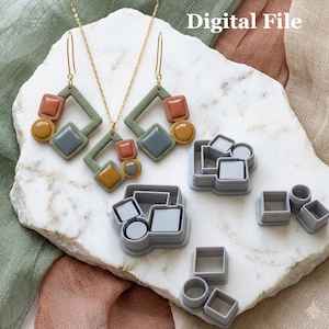 Pode incluir: Um conjunto de joias geométricas incluindo um colar e dois brincos com formas em verde sálvia, terracota, mostarda e azul ardósia, juntamente com vários cortadores de plástico cinzentos. O texto Digital File é visível no canto superior direito.